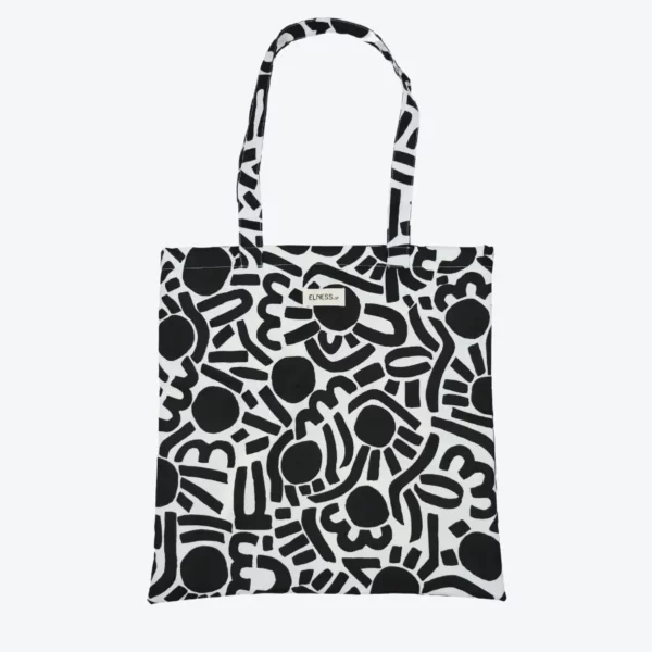 Le sac tote bag est de format carré, avec des anses, il est de couleur noir et blanc intérieur jaune fluo avec des motifs abstrait. Le tissu est imperméable impression en Europe, et dessiné en France par une illustratrice basée en France Stéphanie Piogé