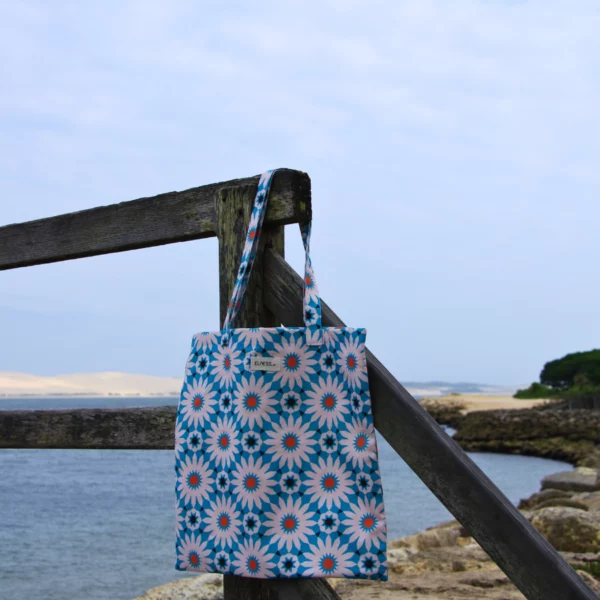 Sac tote bag ou sac banane XL Elness.co avec son motif Azulejos tout droit sorti du Portugal et sa couleur bleu turquoise en 100% coton certifié oeko tex. Il nous embarque directement sur la côté à la plage, c'est la pièce summer 2024. Il est fabriqué en France plus précisément en Charente près d'Angoulême.