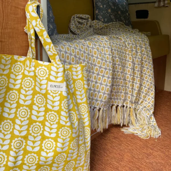 Sac tote bag ou sac banane XL Elness.co avec son motif fleuri et vintage en coton certifié oeko tex. Il a un look très année 70 vintage, très seventies, il est jaune moutarde et blanc écru. Il est fabriqué en France plus précisément en Charente près d'Angoulême. Un tote bag moutard dans un intérieur combi volswagen