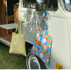 Sac tote bag ou sac banane XL Elness.co avec son motif fleuri et vintage en coton certifié oeko tex. Il a un look très année 70 vintage, très seventies, il est jaune moutarde et blanc écru. Il est fabriqué en France plus précisément en Charente près d'Angoulême. Un tote bag moutard dans un intérieur combi volswagen