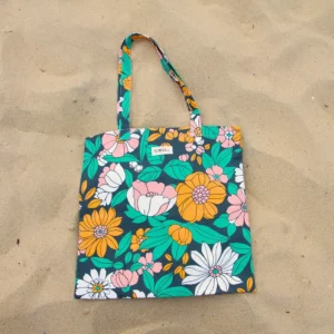 Sac tote bag ou sac banane XL Elness.co avec son motif rétro fleurie, vintage orange, vert rose écru, le tissu est en 100% coton certifié oeko tex.. Le motif apportera du peps et de la fantaisie à vos look monochrome. Il est fabriqué en France plus précisément en Charente près d'Angoulême.