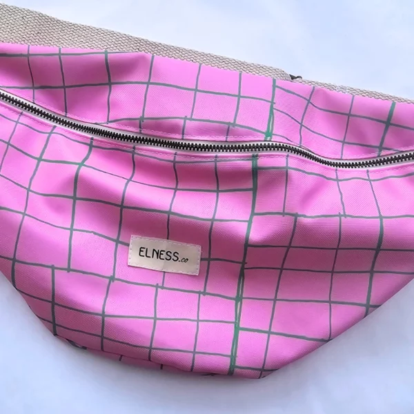 Le sac tote bag est de format carré, avec des anses ou le sac banane XL, il est à carreaux avec des lignes vertes et fond rose bonbon, le cadeau idéal pour la rentrée ou noêl . Le tissu est imperméable impression en Europe, et dessiné en France par une illustratrice basée en France Stéphanie Piogé Il est assemblé, fabriqué dans un atelier d'insertion en Charente près d'Angoulême à Confolens, le CEDIF, un acteur local de l'économie Charentaise. le tissu est imperméable