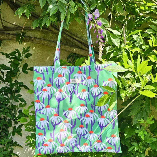 Le sac tote bag est de format carré, avec des anses ou le sac banane XL, il est de couleur vert prairie . Le tissu est imperméable impression en Europe, et dessiné en France par une illustratrice basée en France Stéphanie Piogé Il est assemblé, fabriqué dans un atelier d'insertion en Charente près d'Angoulême à Confolens, le CEDIF, un acteur local de l'économie Charentaise. le tissu est imperméable