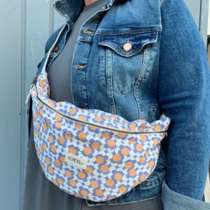 Sac banane XXL ou grand format Elness.co avec son motif trèfles vintage orange et parme, le tissu est en 100% coton certifié oeko tex.. Le motif apportera du peps et de la fantaisie à vos look monochrome. Il est fabriqué en France plus précisément en Charente près d'Angoulême. La pièce éthique et responsable !