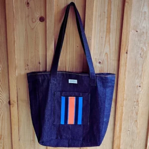 Le grand sac en jean, est le sac idéal pour faire du shopping, ou le sac parfait pour aller en cours, ou pour aller faire du sport. Un sac solide !!! La matière est en jean brut, l'intérieur est coton couleur bleu indigo, un aimant permet de le fermer en toute sécurité ! 2 poches extérieurs dont une poche orange fluo et indigo, la deuxième est en jeans. C'est le cadeau idéal pour la rentrée ou pour Noël. Il est fabriqué en France. Un sac indémodable !