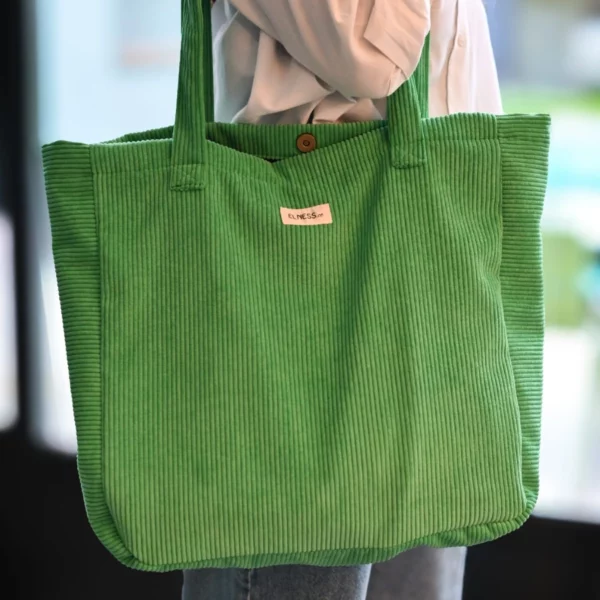 Un grand sac en Velour vert prairie l'intérieur est doublé en coton gris clair a carreaux noirs une petite poche pour ranger ses clés, ses cartes...la fermeture du sac se fait avec un aimant, l'intérieur du sac est entièrement doublé. Fabrication éthique, la fabrication est faite en Charente dans un atelier d'insertion.