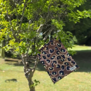 Pochette imperméable et écoresponsable, confectionnée à partir de chutes de tissus et fermée par des liens en coton recyclé, idéale pour transporter maillot mouillé, produits de beauté ou linge sale en voyage.