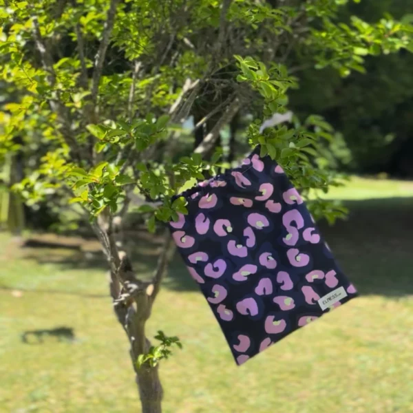 Pochette imperméable et écoresponsable, confectionnée à partir de chutes de tissus et fermée par des liens en coton recyclé, idéale pour transporter maillot mouillé, produits de beauté ou linge sale en voyage.