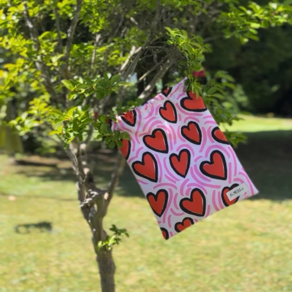 Pochette imperméable et écoresponsable, confectionnée à partir de chutes de tissus et fermée par des liens en coton recyclé, idéale pour transporter maillot mouillé, produits de beauté ou linge sale en voyage.