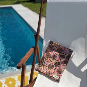 Pochette imperméable et écoresponsable, confectionnée à partir de chutes de tissus et fermée par des liens en coton recyclé, idéale pour transporter maillot mouillé, produits de beauté ou linge sale en voyage.