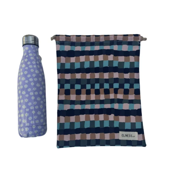 Pochette imperméable et écoresponsable, confectionnée à partir de chutes de tissus et fermée par des liens en coton recyclé, idéale pour transporter maillot mouillé, produits de beauté ou linge sale en voyage.