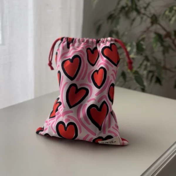 Pochette imperméable et écoresponsable, confectionnée à partir de chutes de tissus et fermée par des liens en coton recyclé, idéale pour transporter maillot mouillé, produits de beauté ou linge sale en voyage.