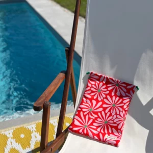 Pochette imperméable et écoresponsable, confectionnée à partir de chutes de tissus et fermée par des liens en coton recyclé, idéale pour transporter maillot mouillé, produits de beauté ou linge sale en voyage.