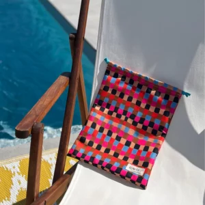 Pochette imperméable et écoresponsable, confectionnée à partir de chutes de tissus et fermée par des liens en coton recyclé, idéale pour transporter maillot mouillé, produits de beauté ou linge sale en voyage.