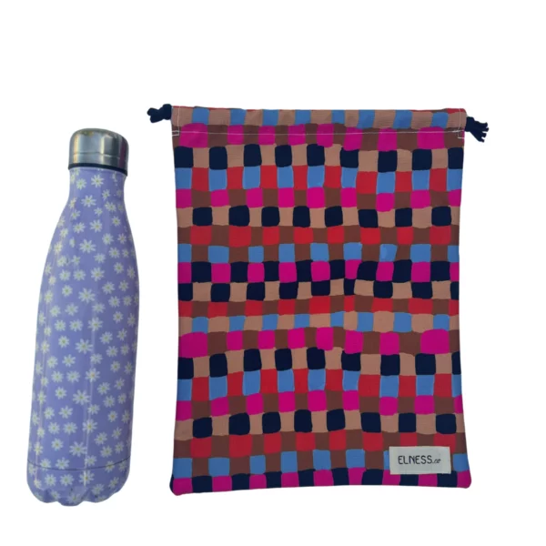 Pochette imperméable et écoresponsable, confectionnée à partir de chutes de tissus et fermée par des liens en coton recyclé, idéale pour transporter maillot mouillé, produits de beauté ou linge sale en voyage.